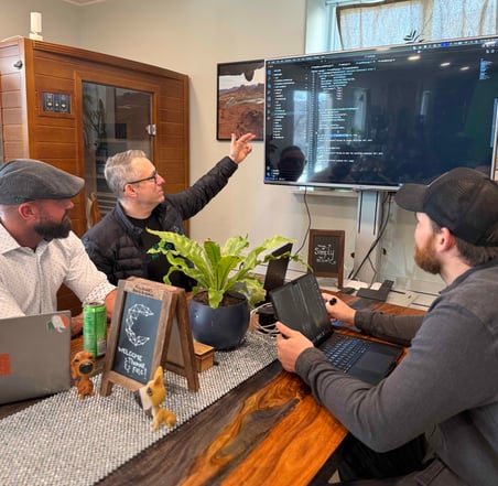 software engineer demonstrating at table to his team