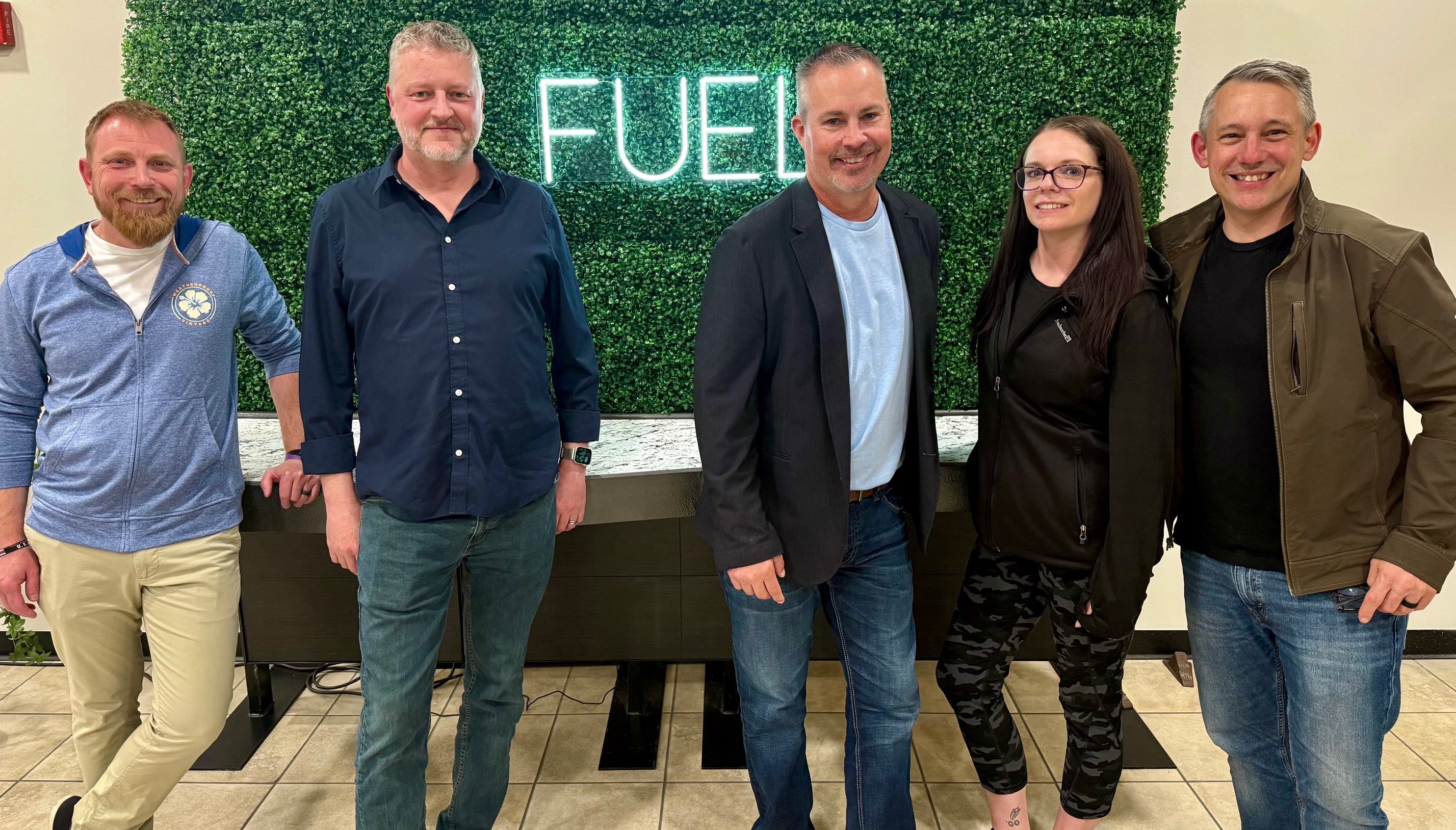 A smiling group of professionals in the FUEL co-working space