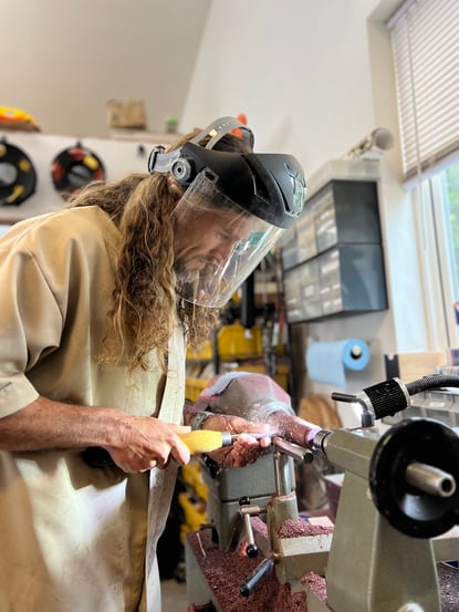 blond man using a lathe